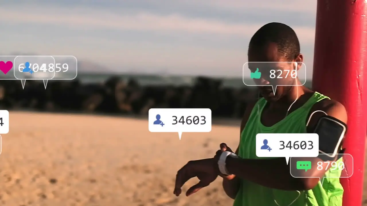 Animation of social media icons against african american fit man using smartwatch at a beach