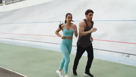 Fitness couple training together at modern stadium Sporty couple running