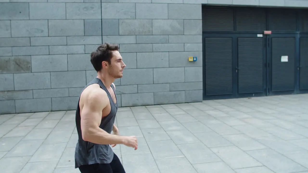 Sporty man running outdoor Male runner jogging on city street in slow motion