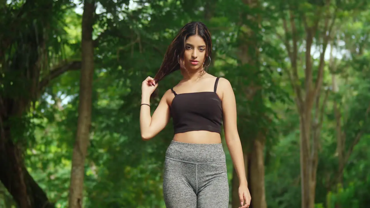 A young girl in sports gear adds vitality to the tropical park with her exercise routine