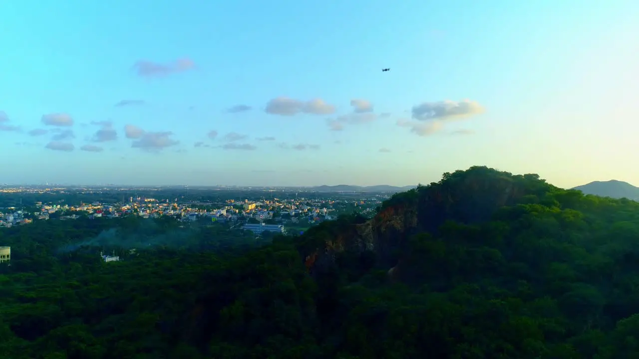 Drone shot flying upwards showing another drone flying downwards with a mountain in the back drop