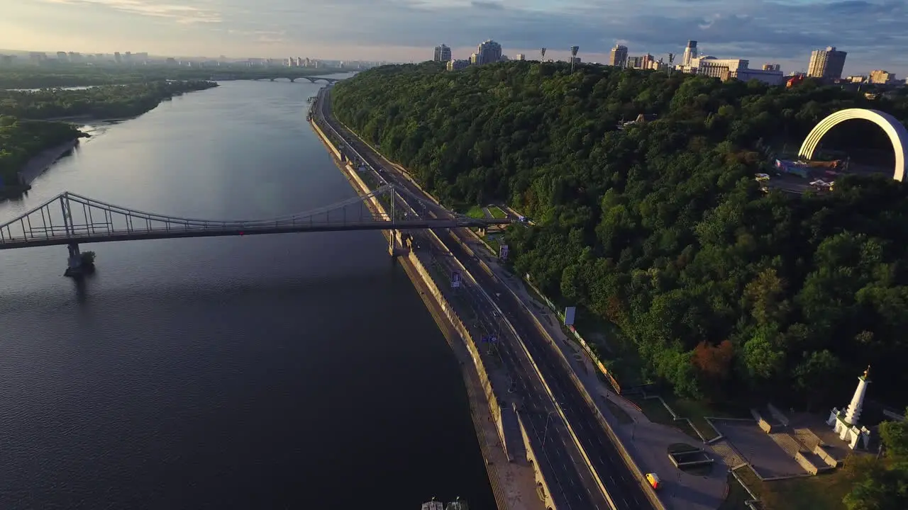 Car moving on highway along river in summer city Aerial view urban sightseeing