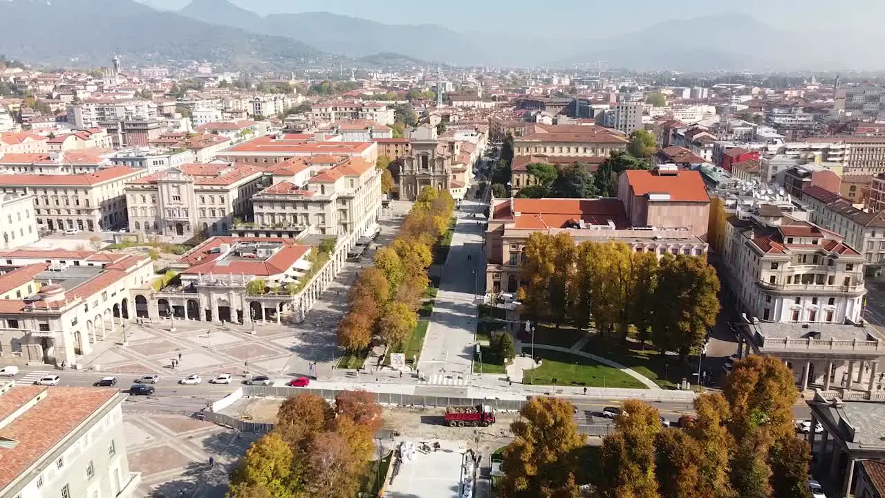 Sun shine over Bergamo city downtown aerial fly backward