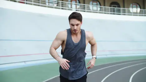 Male runner running at modern track Sport man running on racetrack