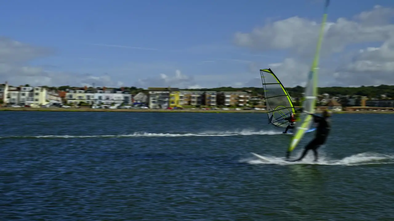 Water sports activity Windsurfers in slow motion pass each other on West Kirby marine lake