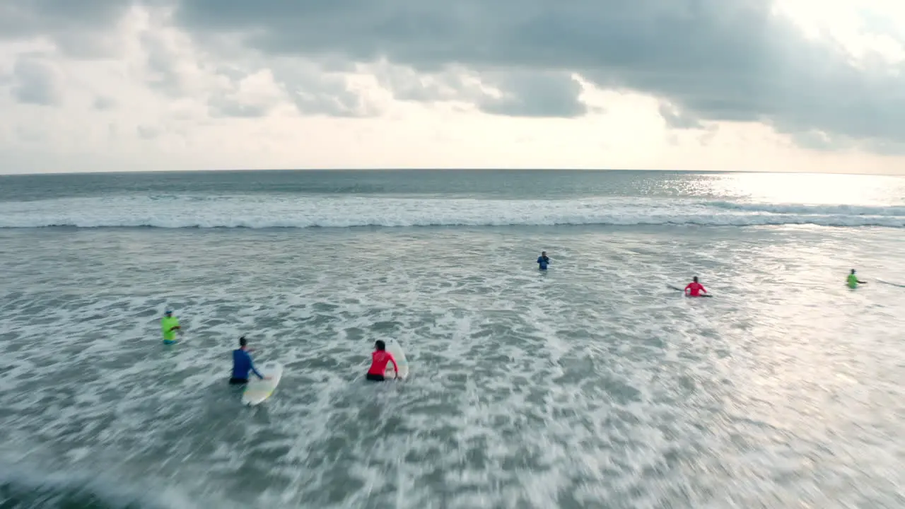 4K Aerial Drone Flying Low and Fast over Group of Surfers on the Sea