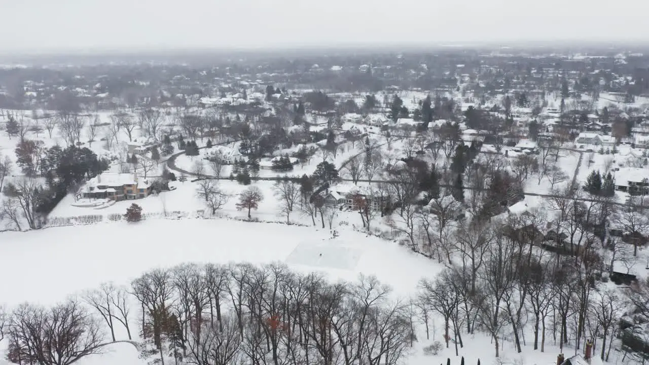 Aerial people skating on outdoor ice rink on frozen lake during winter