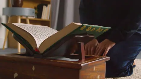 Close Up Of Muslim Woman At Home Kneeling And Reciting From The Quran 2