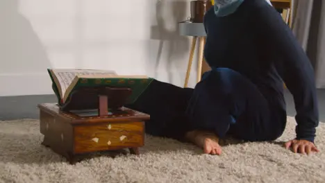 Close Up Of Muslim Woman At Home Sitting And Reciting From The Quran