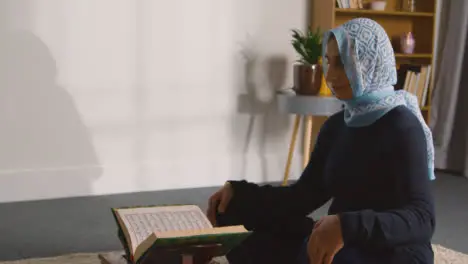 Muslim Woman At Home Sitting And Reciting From The Quran