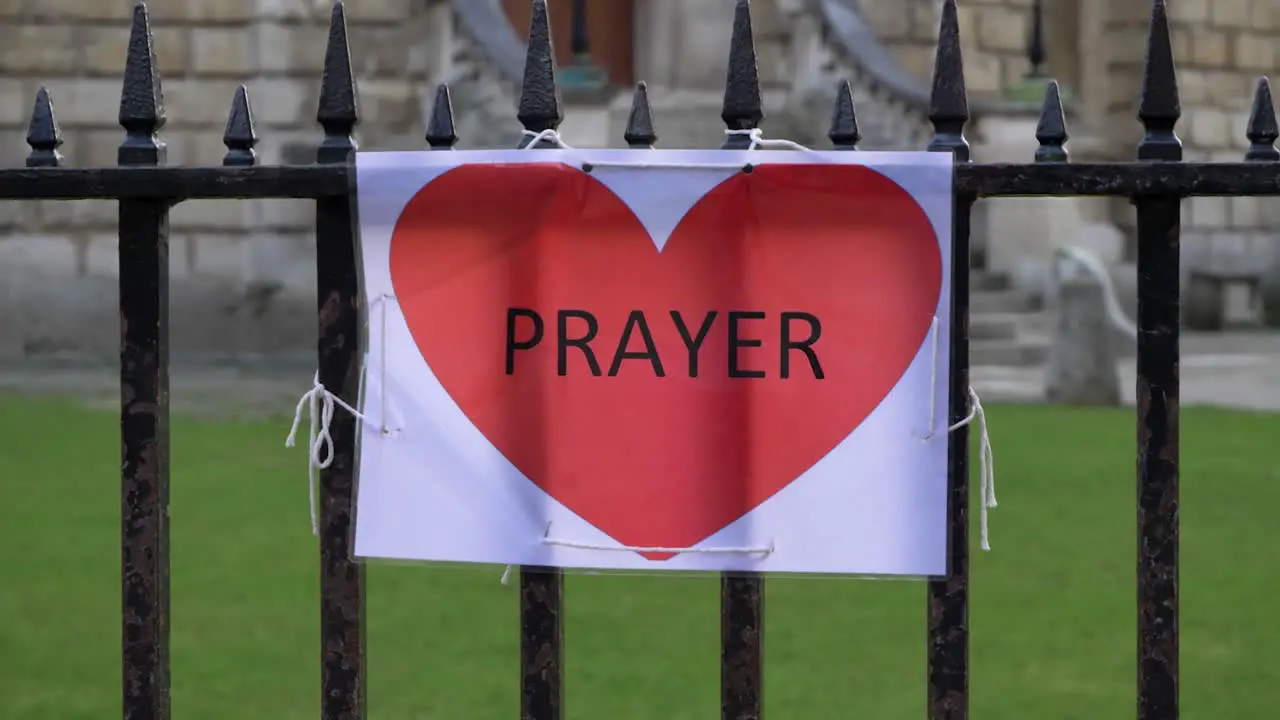 Handheld Close Up Shot of A4 Prayer Sign Tied to a Railing 