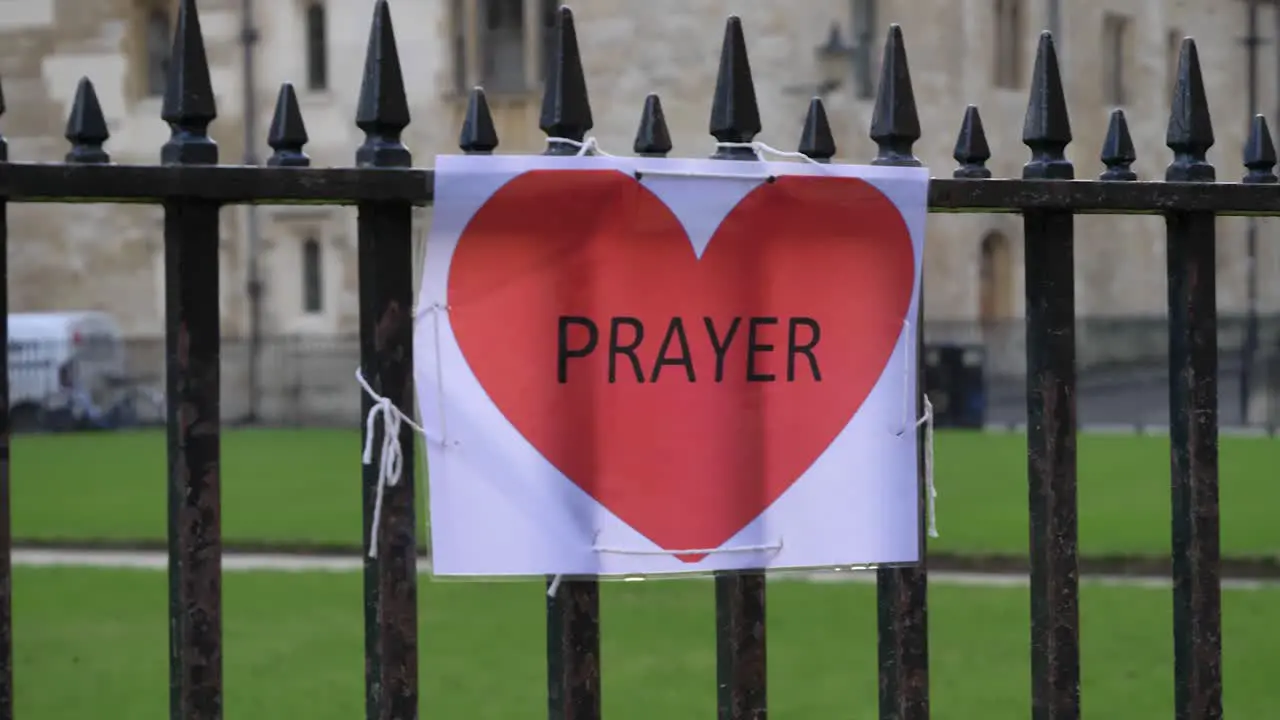 Handheld Close Up Shot of A4 Prayer Sign Tied to Railing 