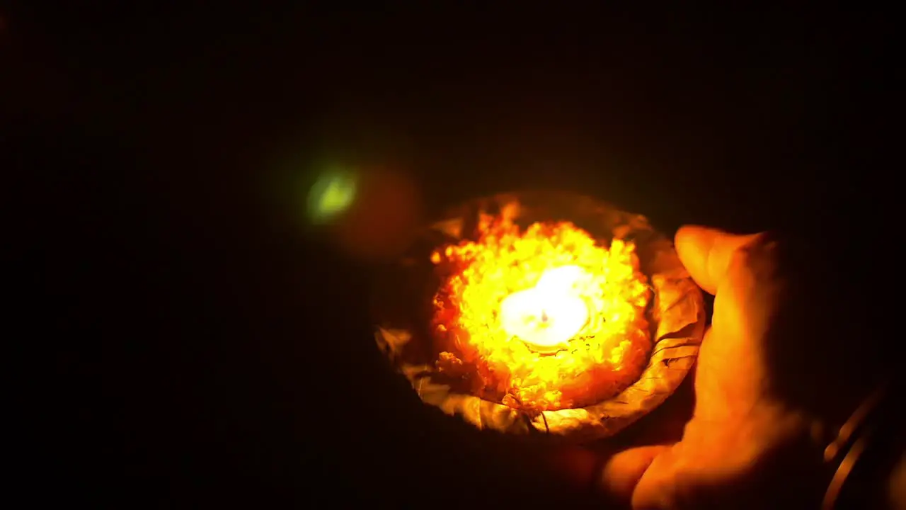 Man Places a Ceremonial Candle in the Ganges