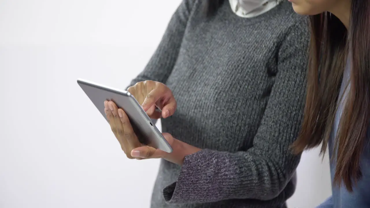 Close Up of Women Working on Tablet