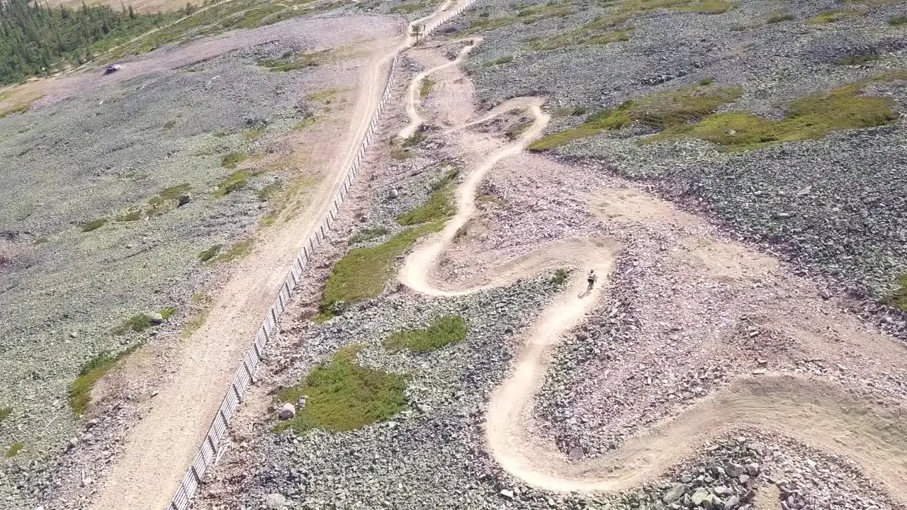 Young man biking downs curving on a dowhill biking track in Lapland Finland