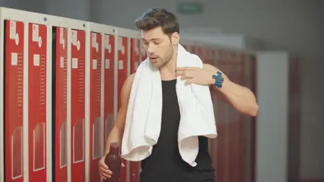 Tired man coming into dressing room after workout