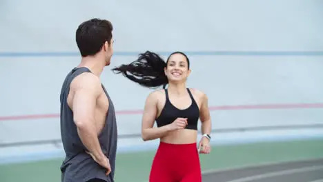 Female woman jogging on running track Coach man training woman at stadium