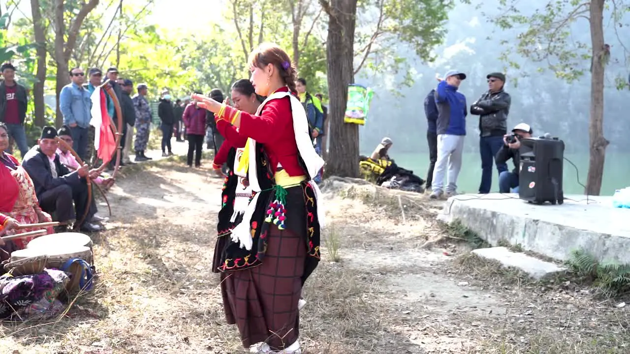 Two Nepali women in traditional Nepali dress dancing in the music played by their band using traditional Nepali instruments