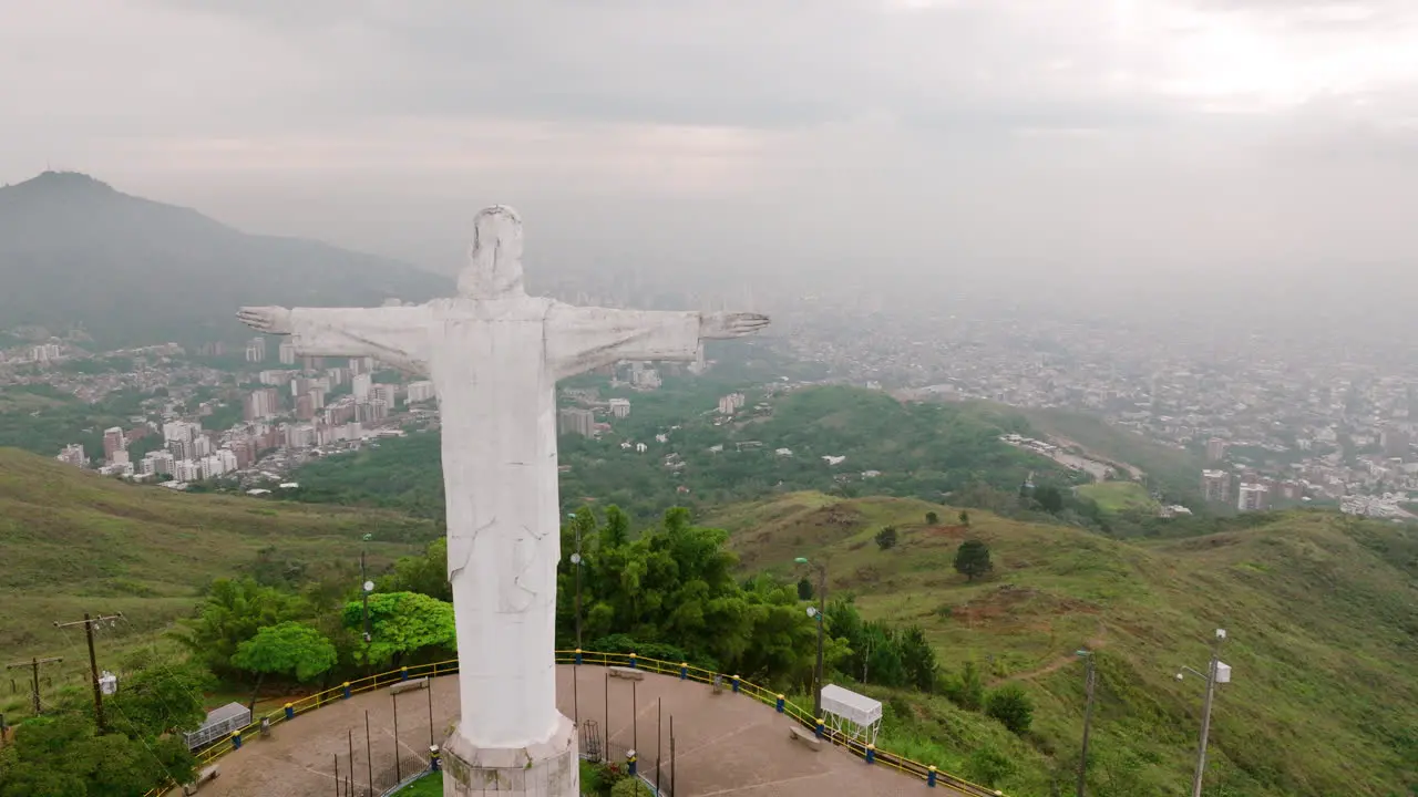 Aerial footage flying past the right side of the Cristo Rey Jesus statue on top of a mountain outside of Cali Colombia