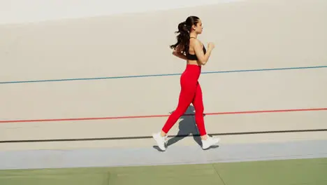 Fit woman jogging on stadium track Woman runner running in slow motion