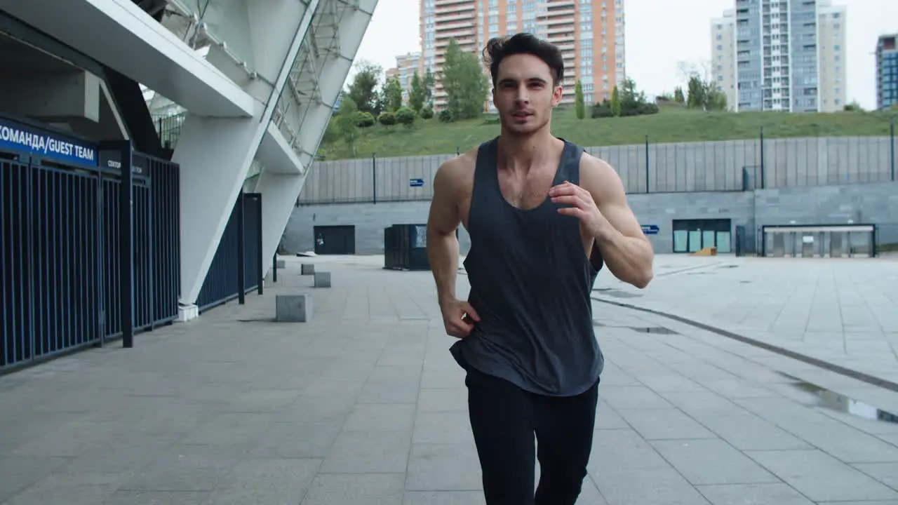 Sportsman running at cardio training outdoor Front view of athlete man jogging