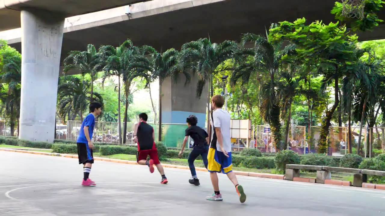 Kids Playing Basketball Under Highway in Saphan Taksin District of Bangkok Thailand