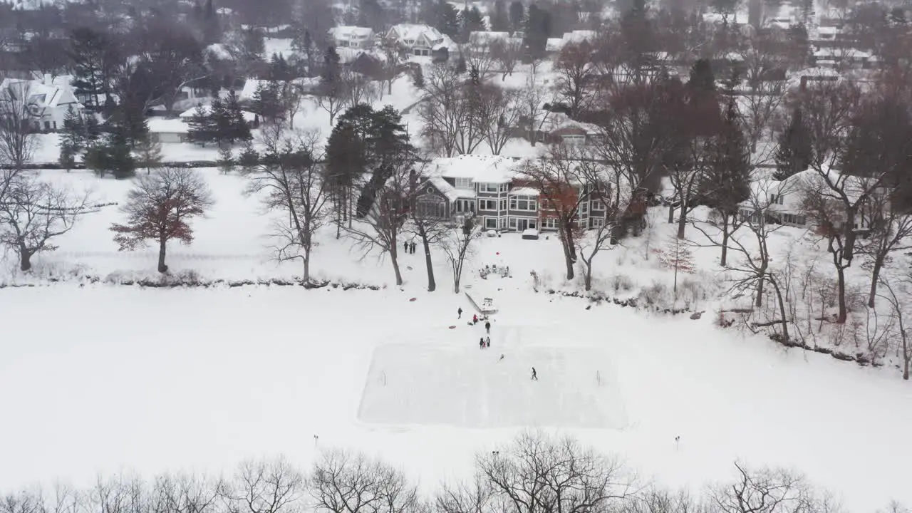 Aerial family and friends skating on a homemade backyard ice hockey rink