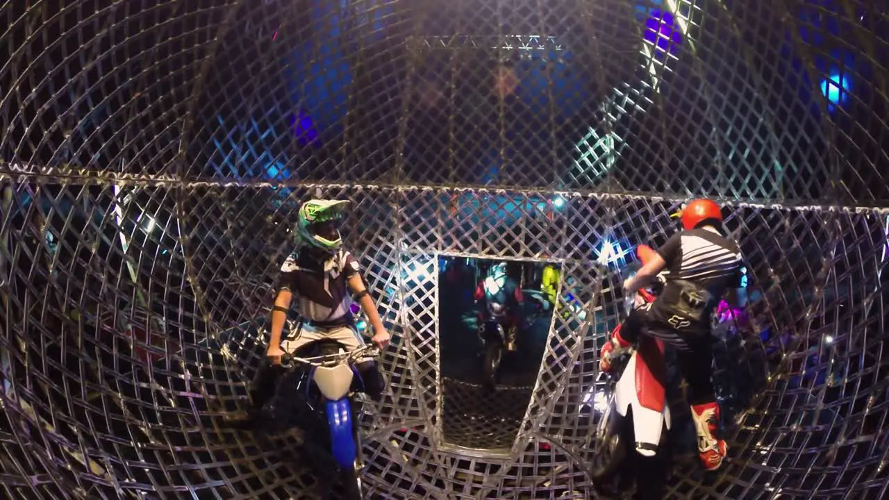 five motocrosser in a iron cage driving out to the stage for beginning of the show