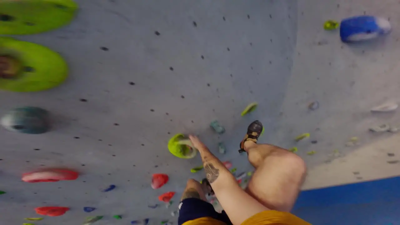 Climber training on an artificial climbing wall first-person shot