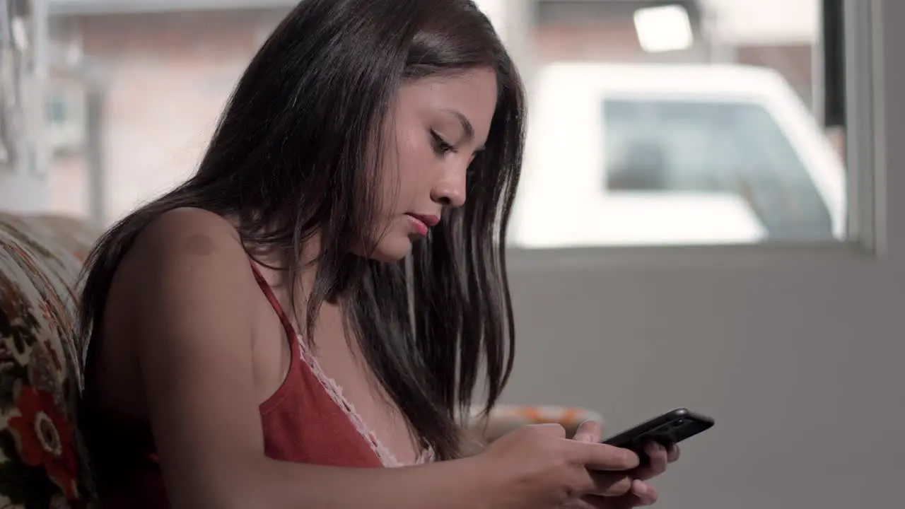 Side view of a mulatto girl using a smartphone displaying digital connection and technological skill in an interconnected world