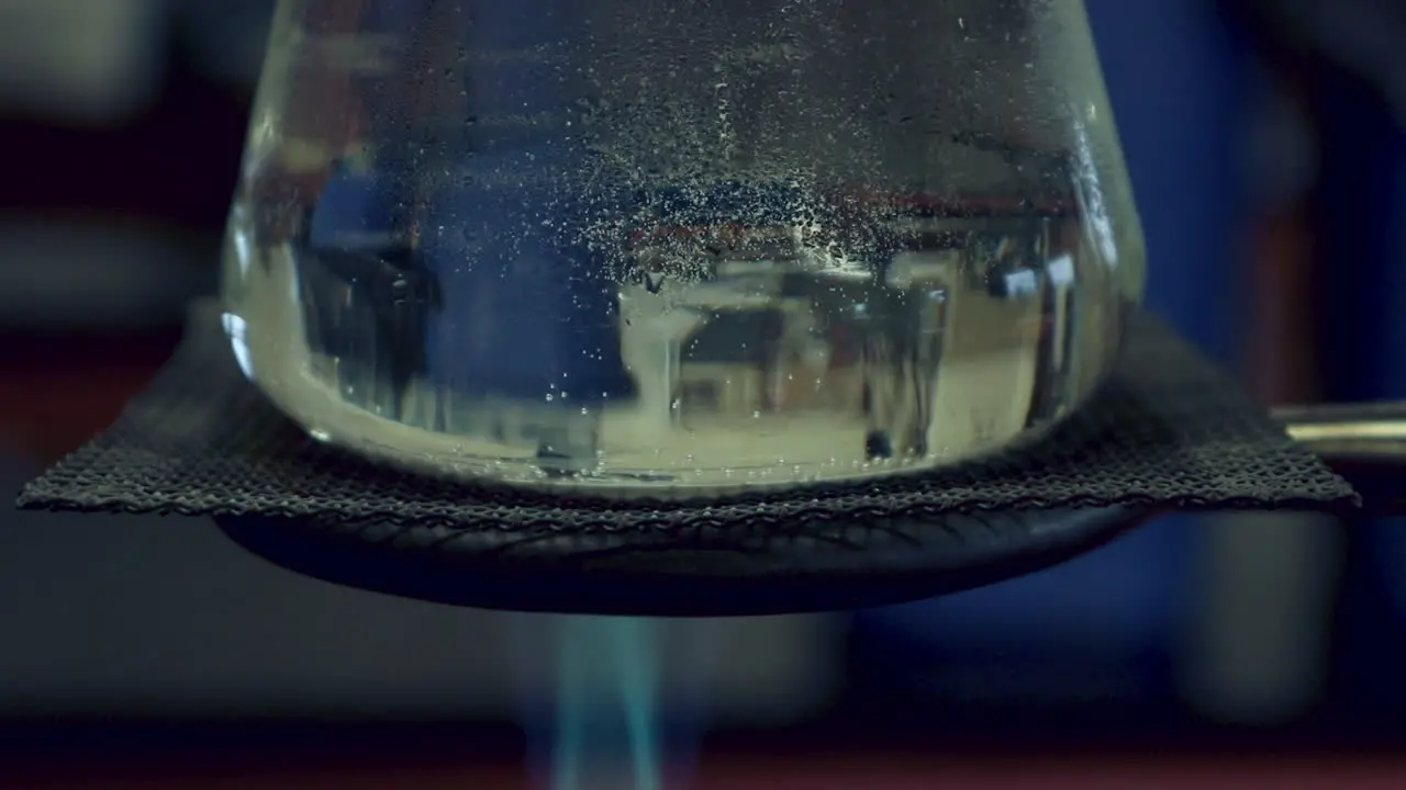 Close up of Erlenmyer Flask that is being heated by a bunsen burner condensation on top heat waves visible in flask