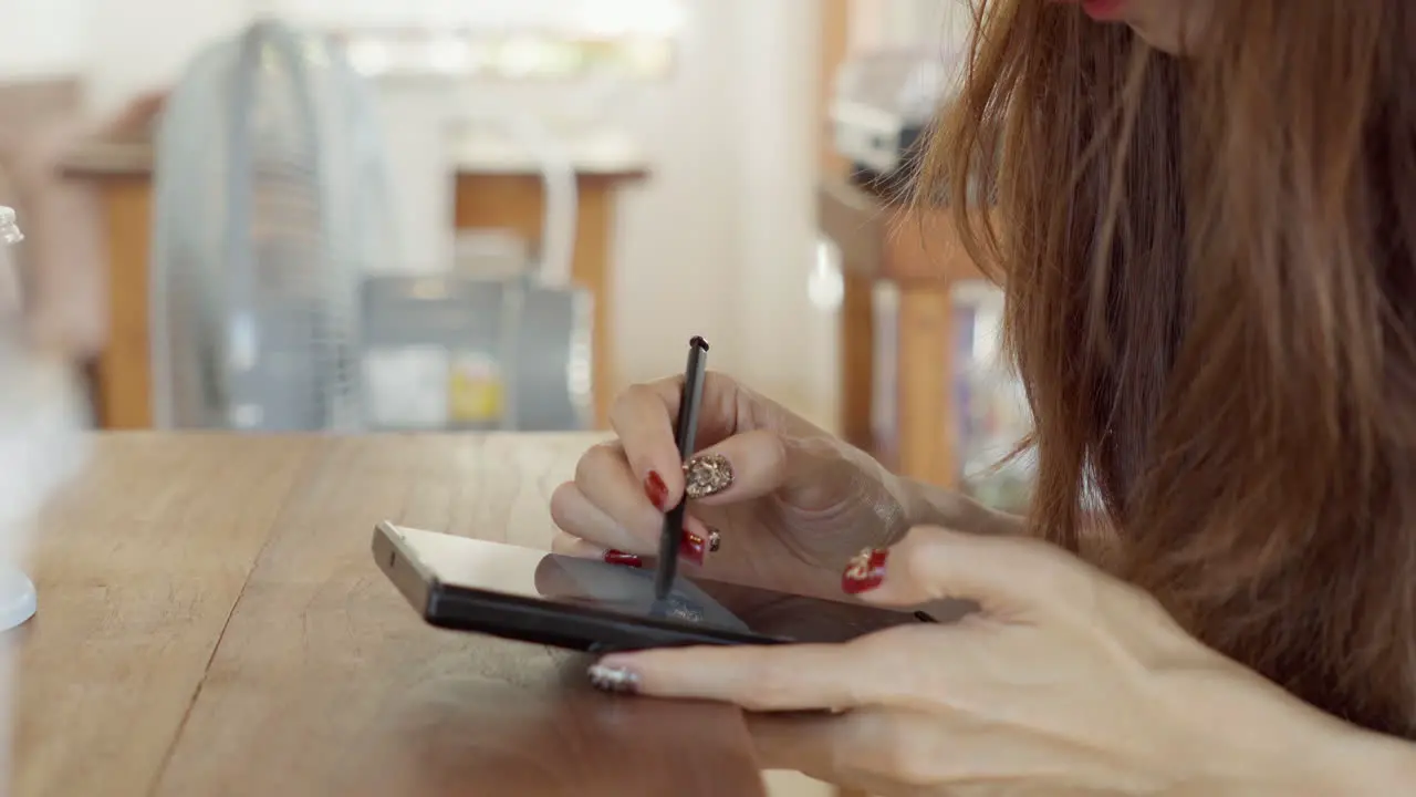 Woman hand using digital stylus pen with smartphone