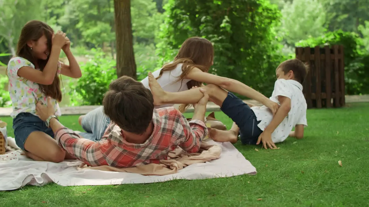 Parents playing with children in park Kids and parents lying on blanket