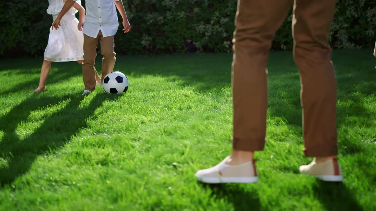 Children and parents legs playing football Family running with soccer ball