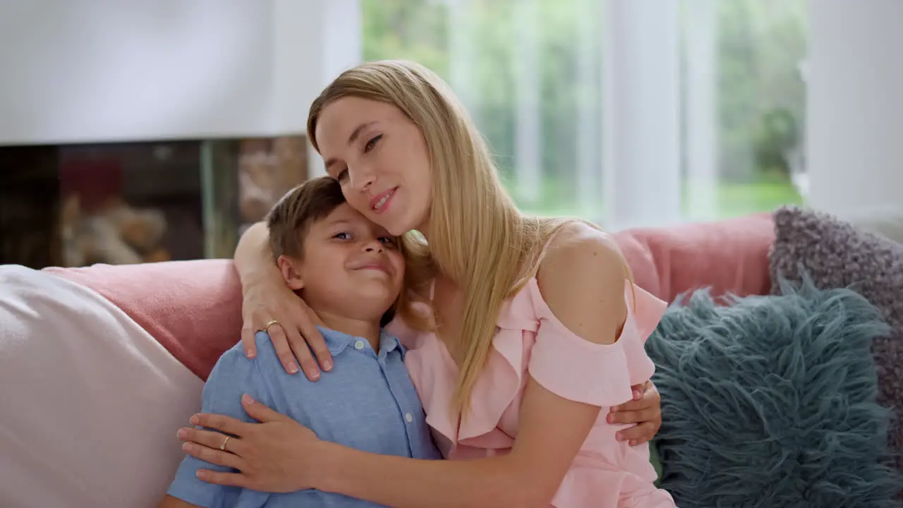 Cheerful boy hugging mother Smiling woman embracing son at home