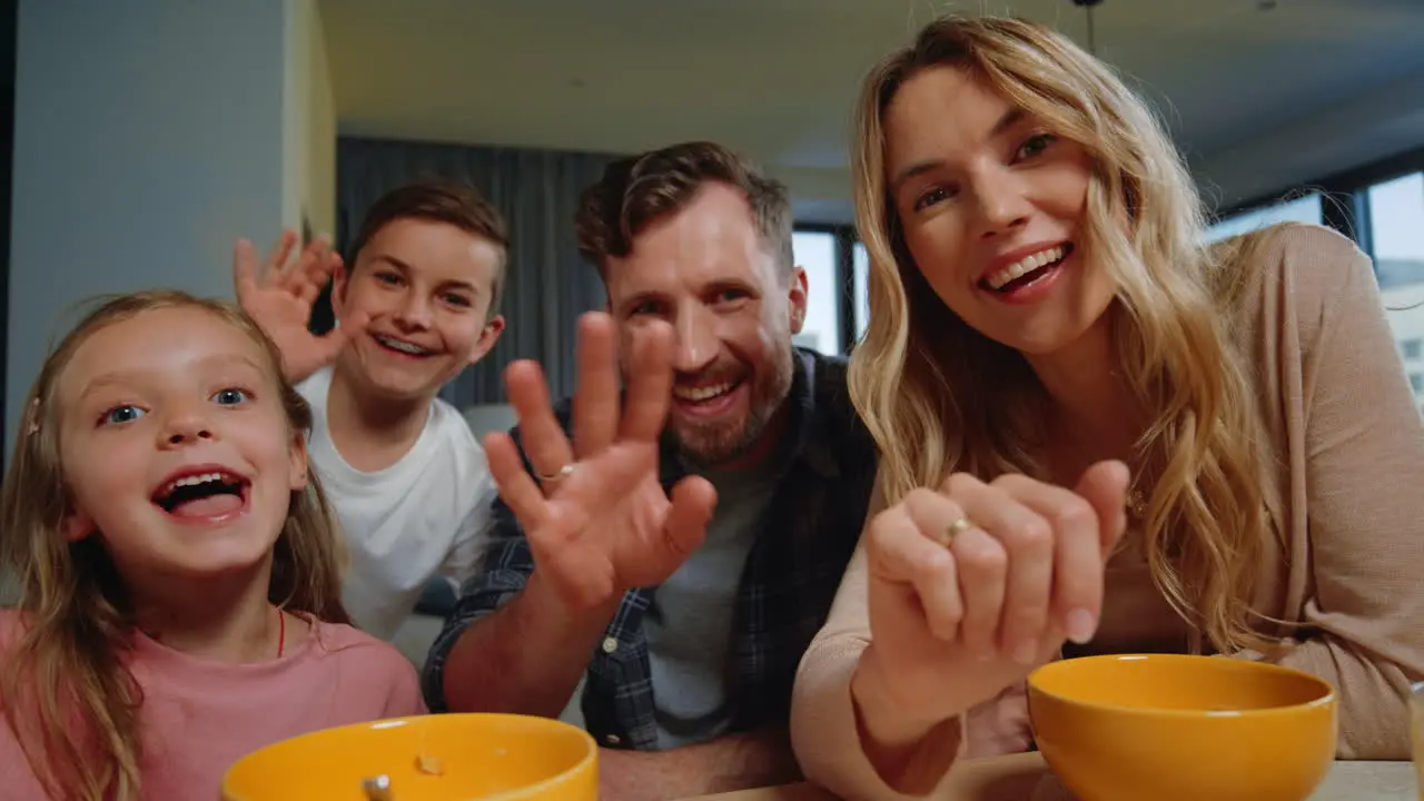 Parents kids looking camera home Family waving hands during morning video call