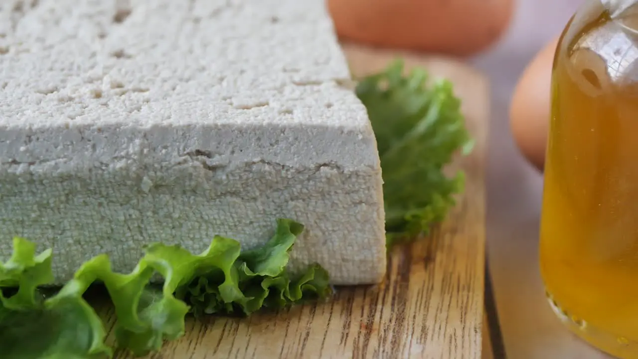 Top view of slice of tofu on a chopping board on table 