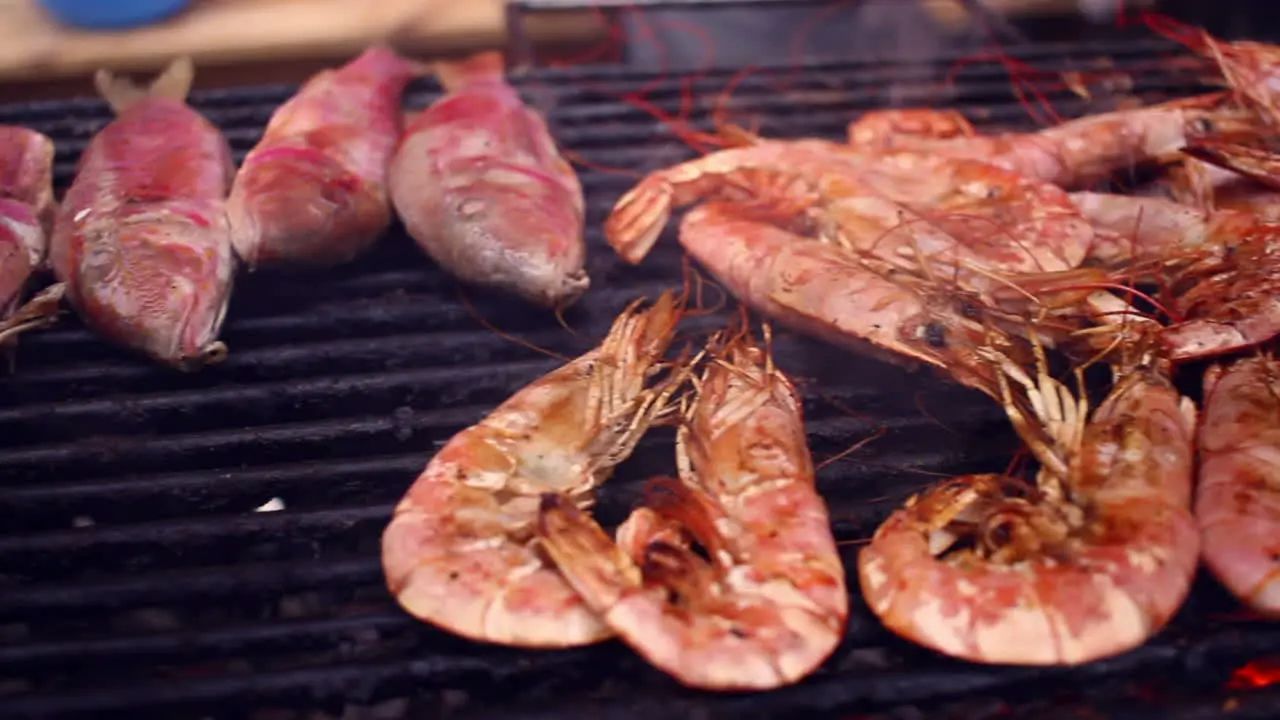 Panorama of grilled red shrimps and other seafood on barbecue