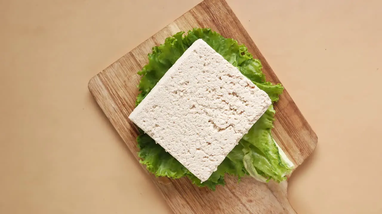 Top view of slice of a tofu on a chopping board