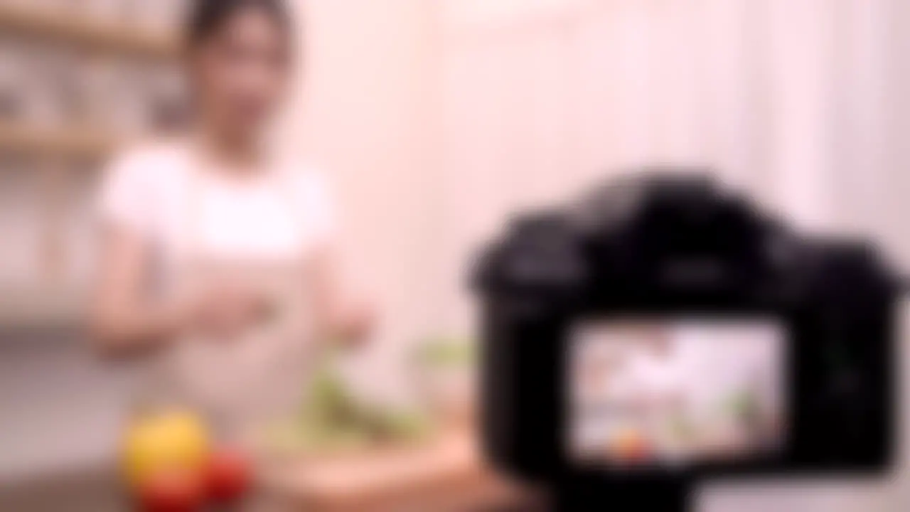 Blurred shot of female food influencer chef creating cooking video content online YouTube creator concept