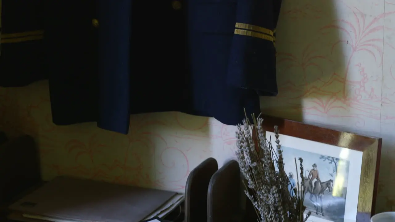 Old french navy uniform vest above a desktop with old artifacts on it