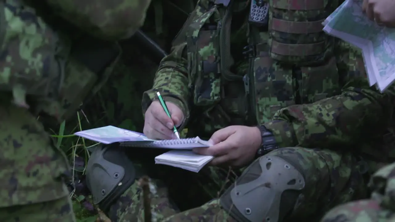 Soldiers planning strategy in the forest mid shot handheld slow motion