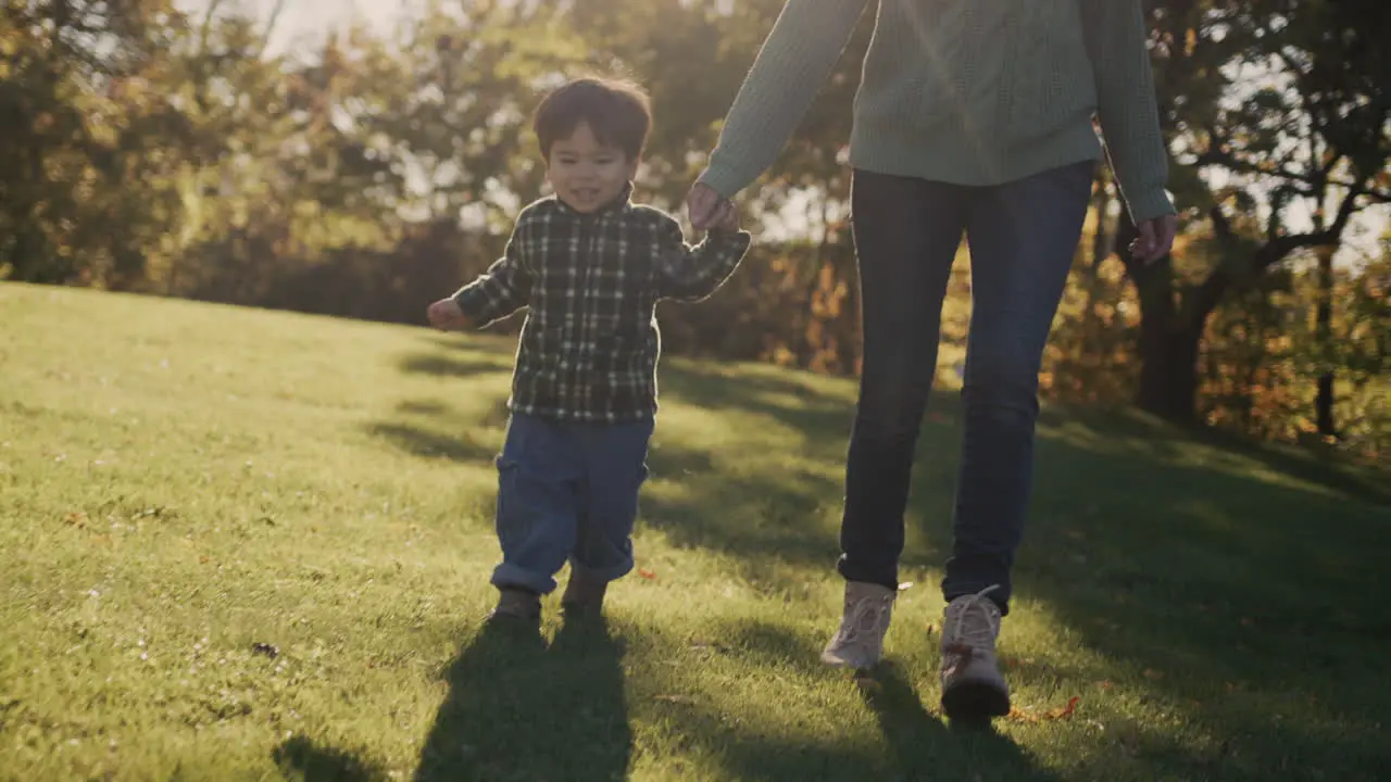 A mother with a cheerful Asian baby walks in the park