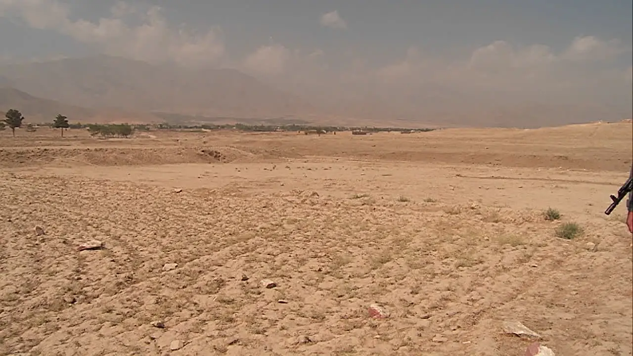 Pan of landmine field to ANA soldier outside Kabul Afghanistan