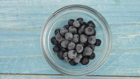 Timelapse footage of freezing fruits berries on the glass plate Frozen food Frosting of blueberry