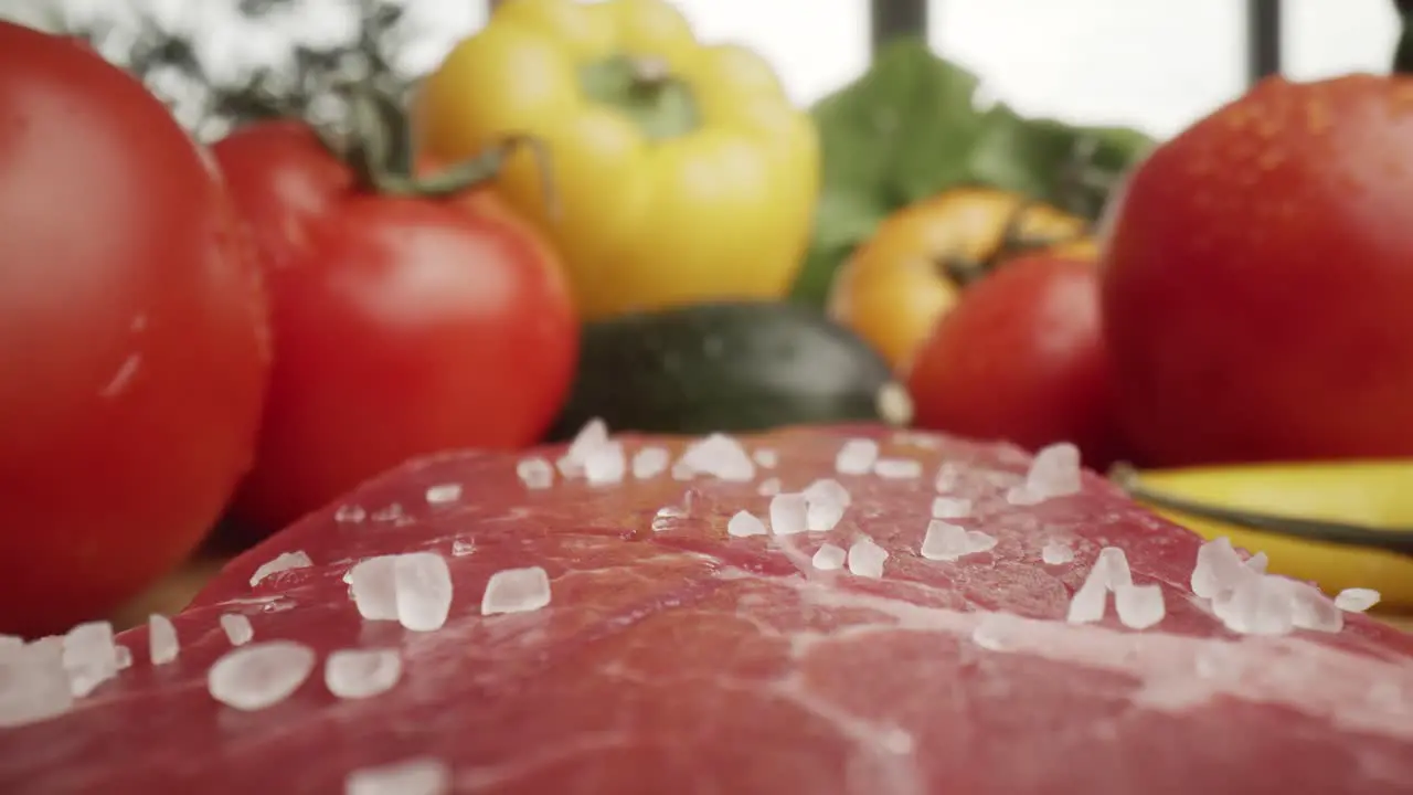 Zoom out macro video of sea salt on raw steak