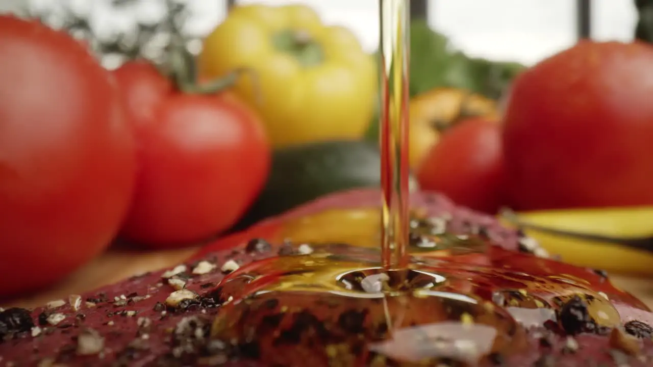 Zoom out macro video of olive oil on raw steak