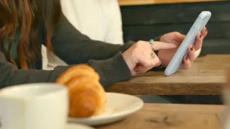 Woman Using Phone in Cafe