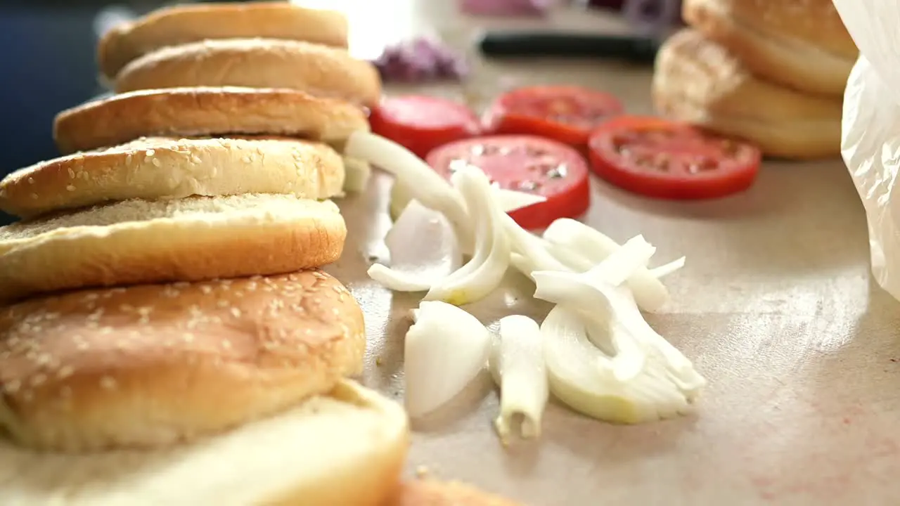 Fresh ingredients for hamburgers on table in kitchen