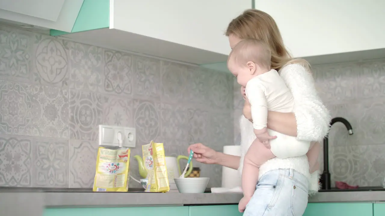 Mother preparing food for little baby at kitchen Mother care child